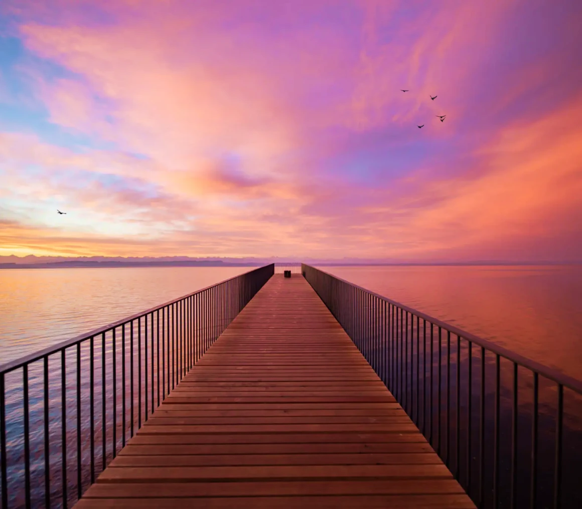 Wooden dock under vibrant sunset hues